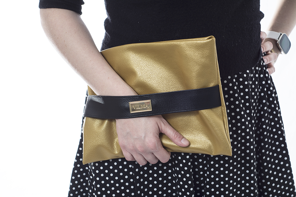 Holding a shiny, gold purse